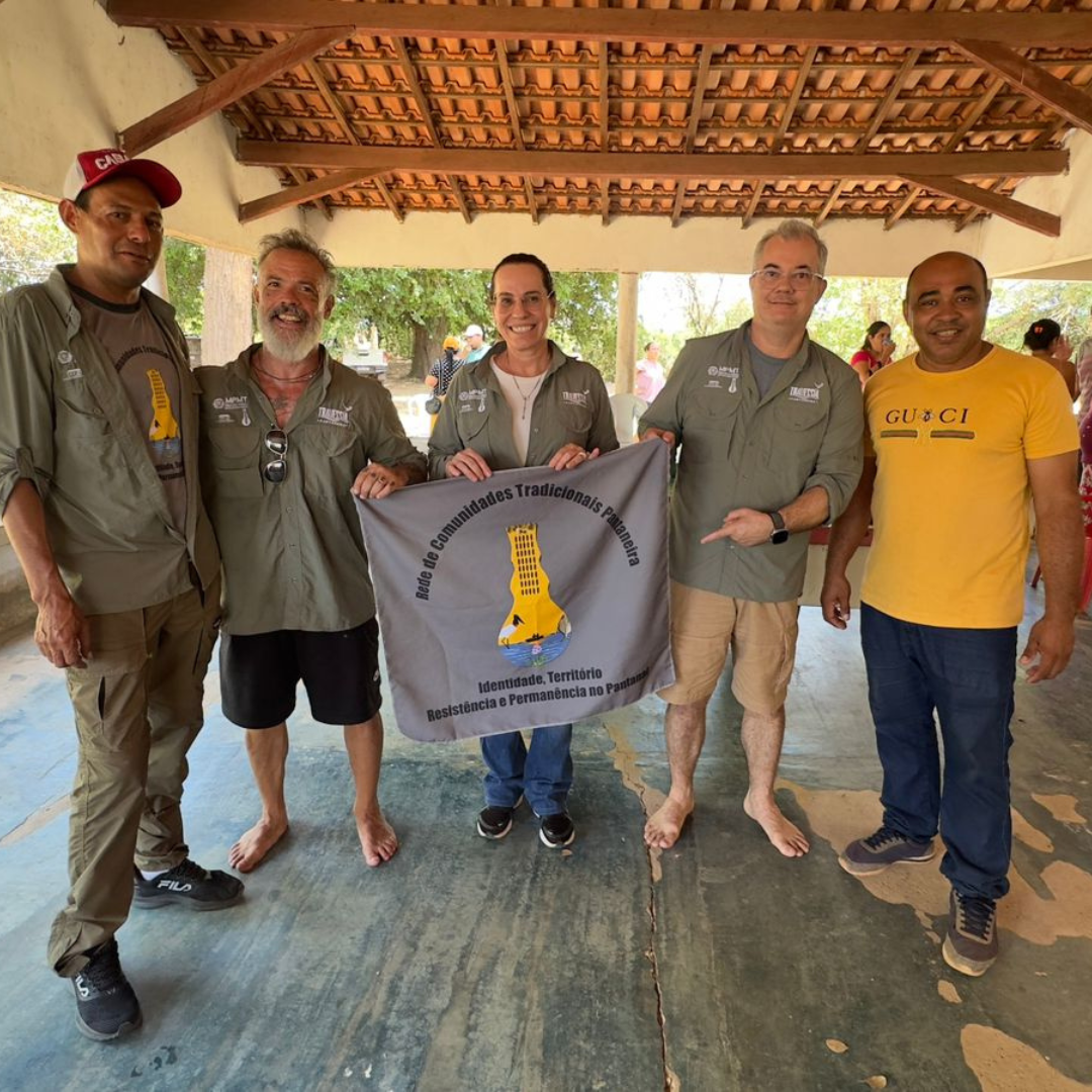 Foto dos promotores do MPEMT com membros e bandeira da Rede de Comunidades Tradicionais Pantaneiras